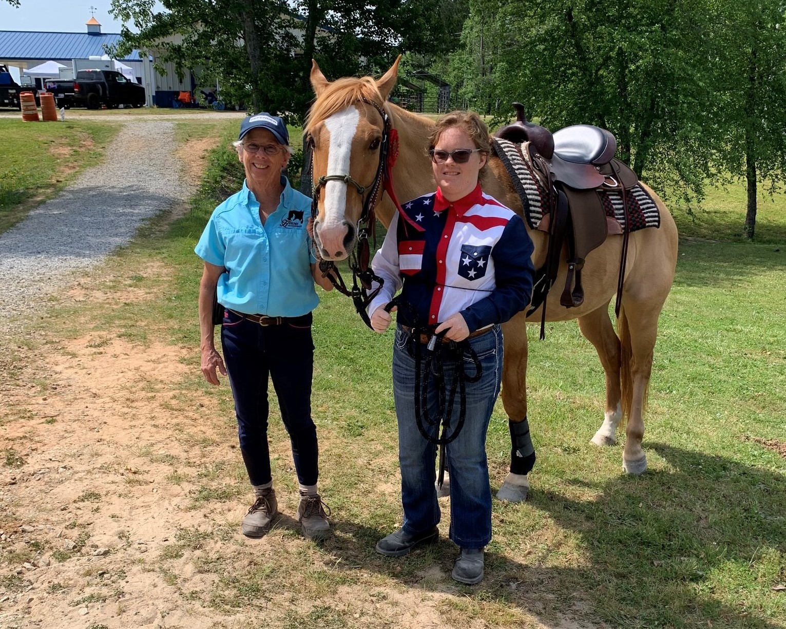 Photo of Heroes on Horseback staff member and rider both posing with horse outdoors
