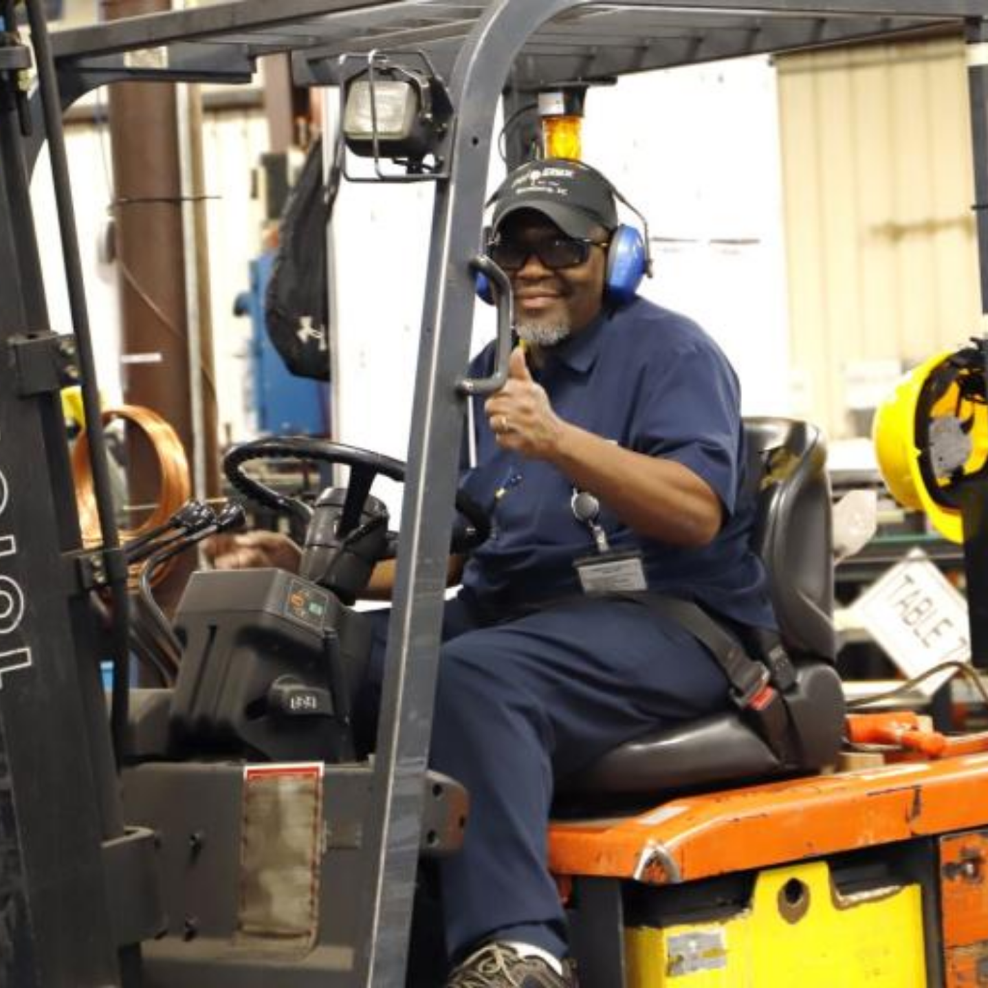 Phoenix Specialty Mfg. Co. staff member giving thumbs up to camera as he operates a forklift