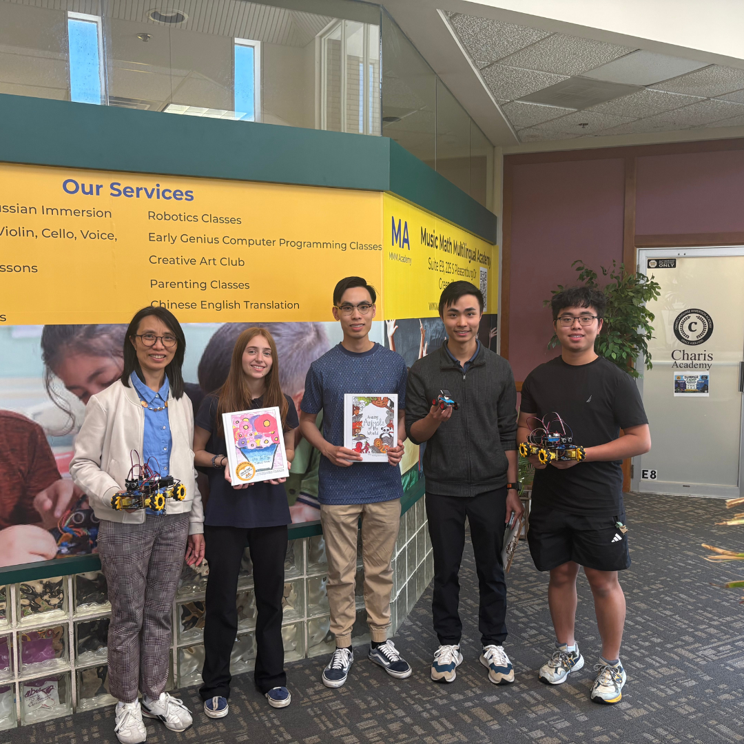 Five people, three boys, and two women, are standing, all holding items, posing, and smiling for the picture 