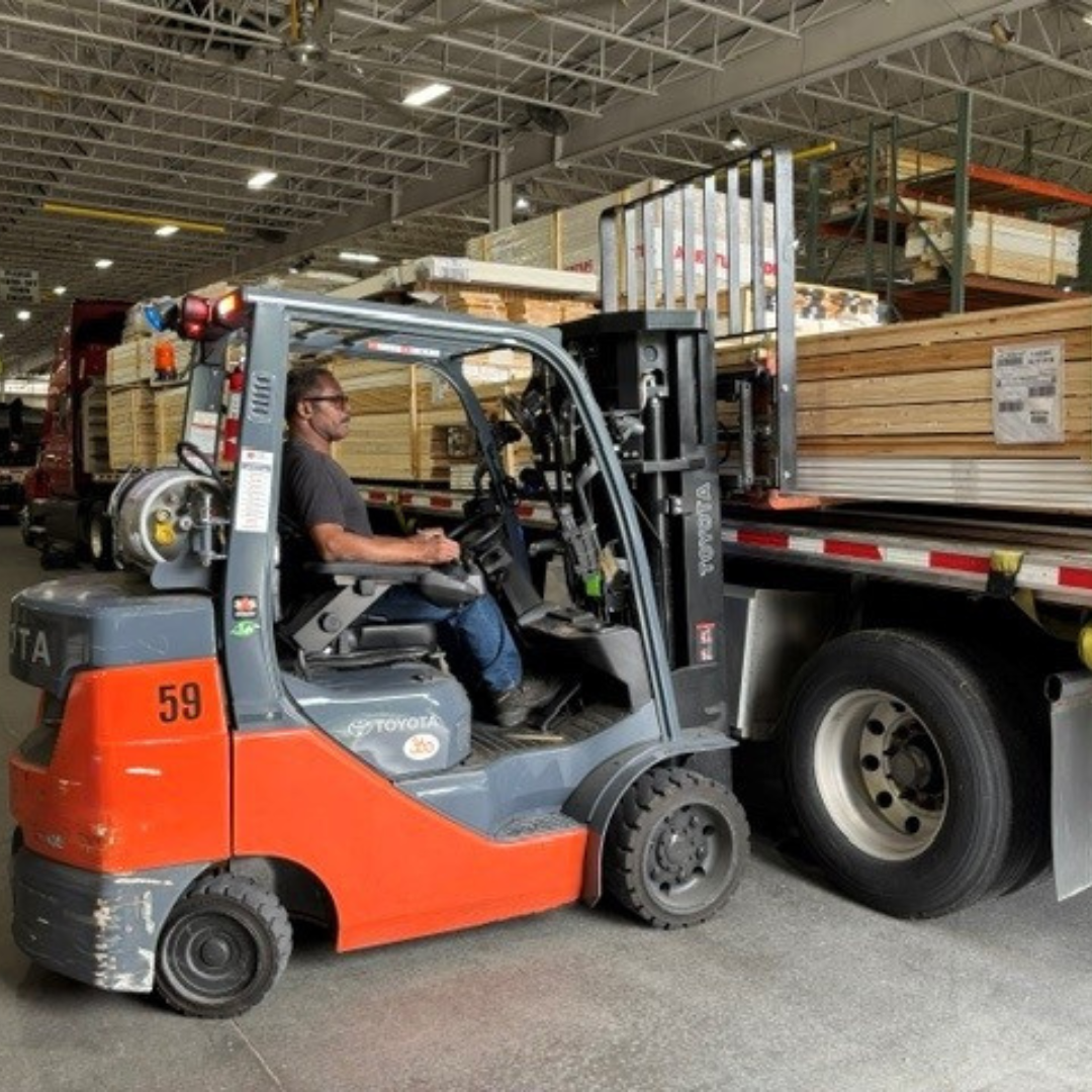 A man is operating a forklift within a warehouse 