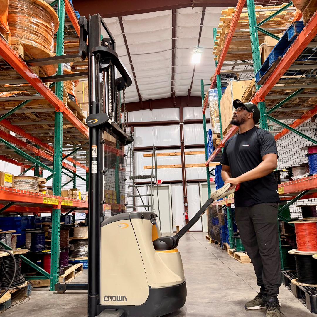 A man is operating a reach extender, attempting to get items down from a high shelf