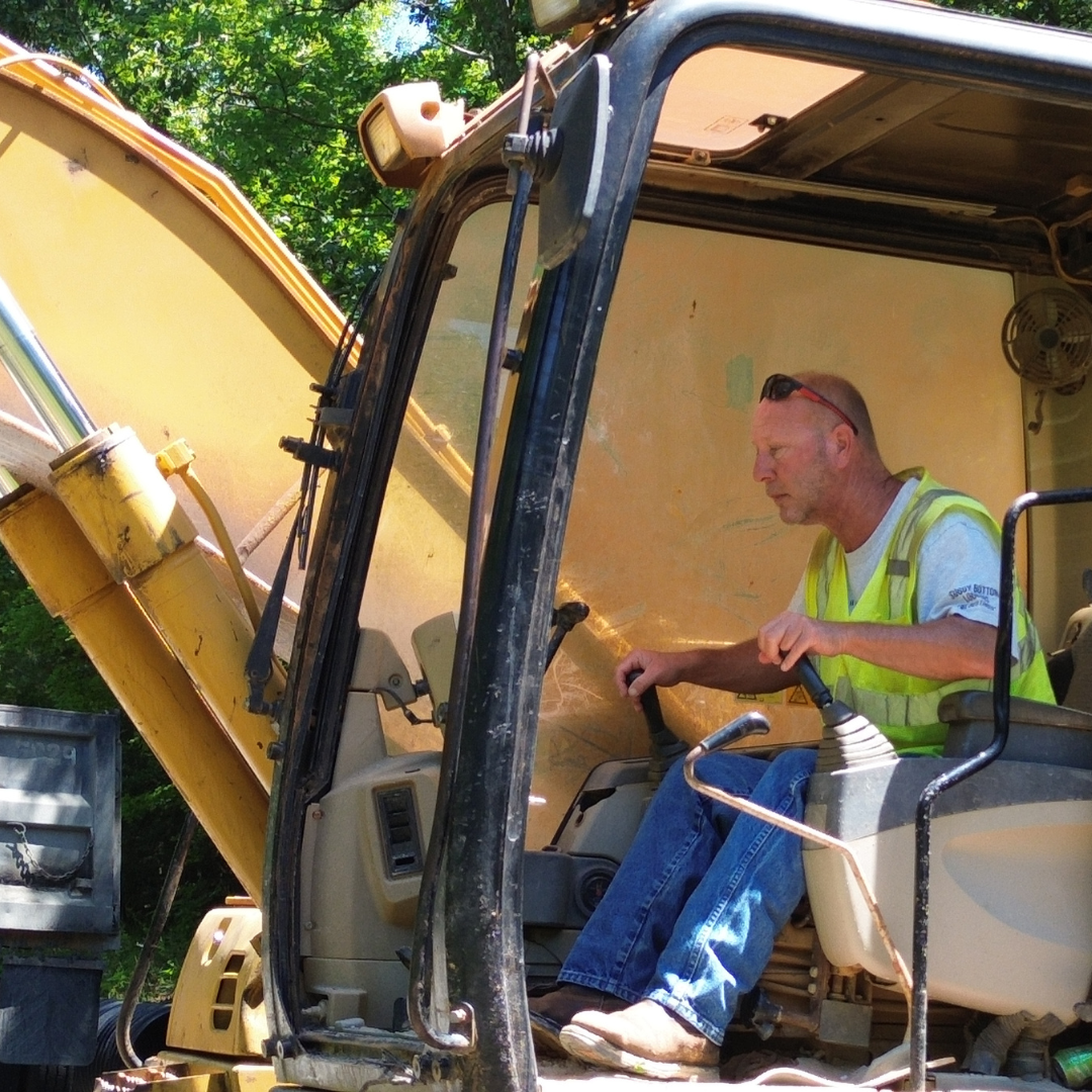A man sitting and operating an excavator