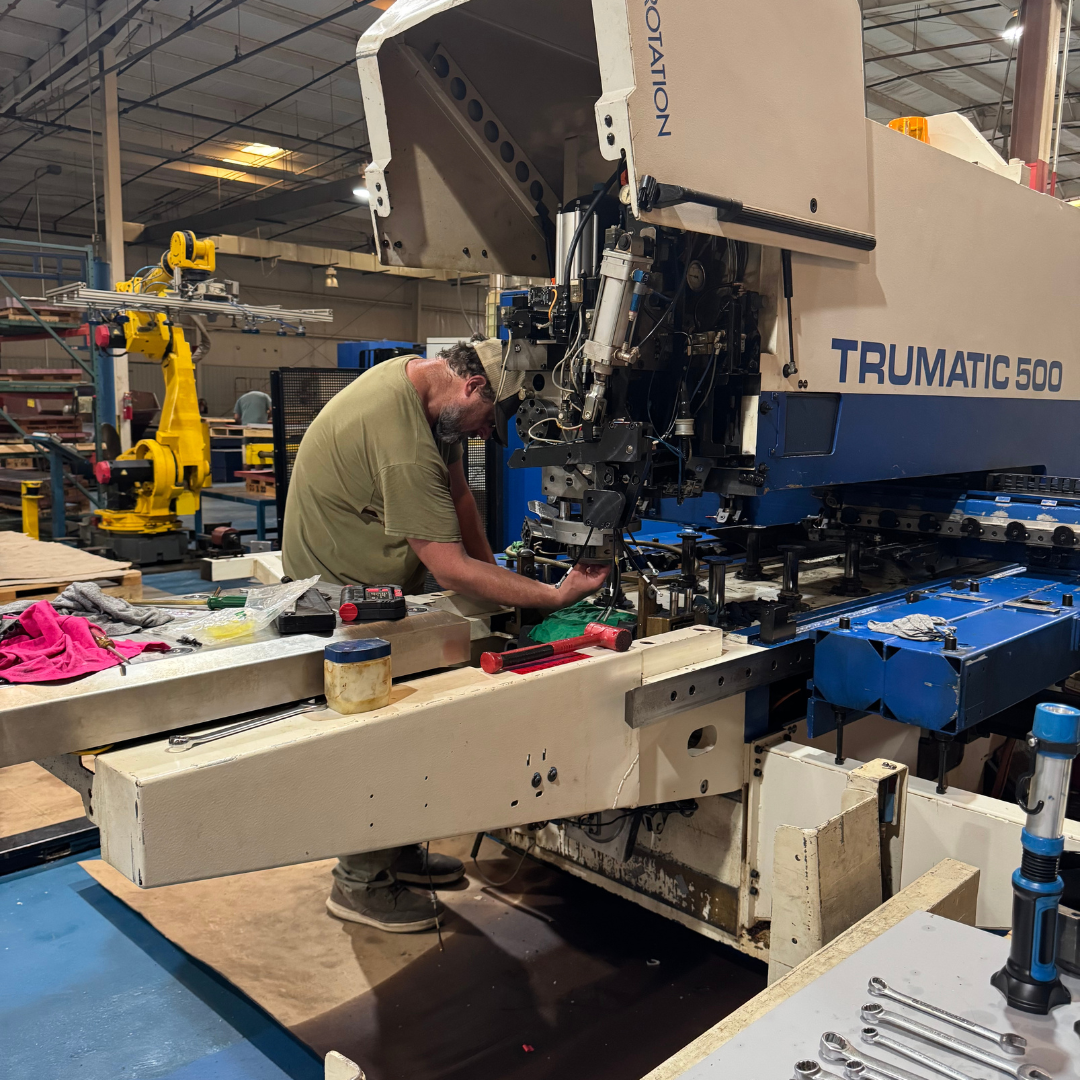 A man works a big machine to print items onto various materials