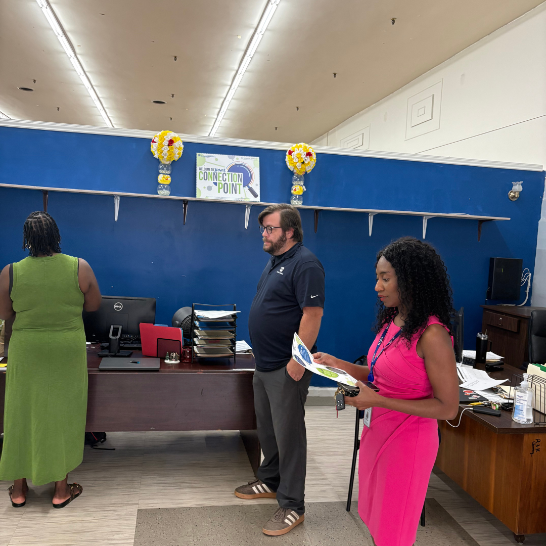 A man and a woman stand in the middle of a room, reading off a piece of paper