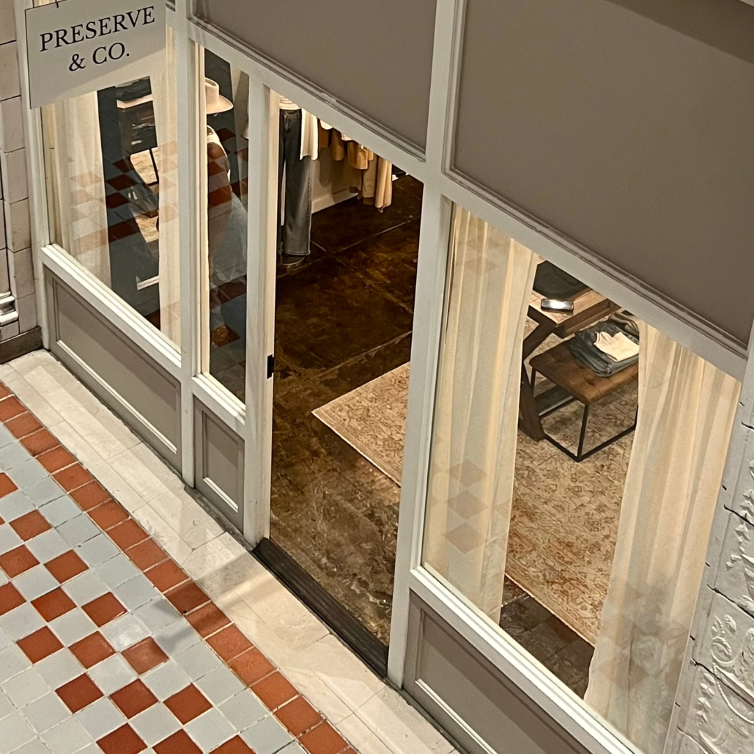 The outside of Preserve & Co. The image shows the front of the space, the door, and the sign above the door