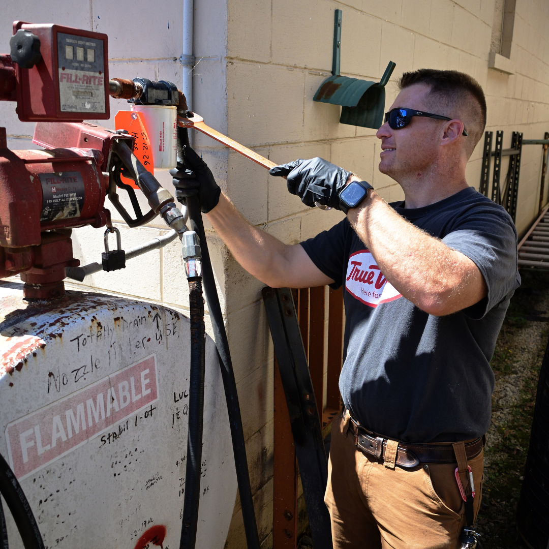 A Triangle Hardware worker uses a tool to stabilize a machine 