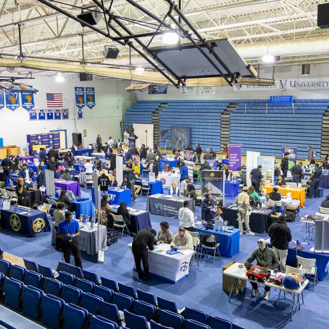 An auditorium at the university with lots of booths and people