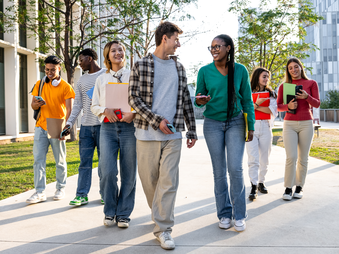 Seven college students walking and talking on campus.