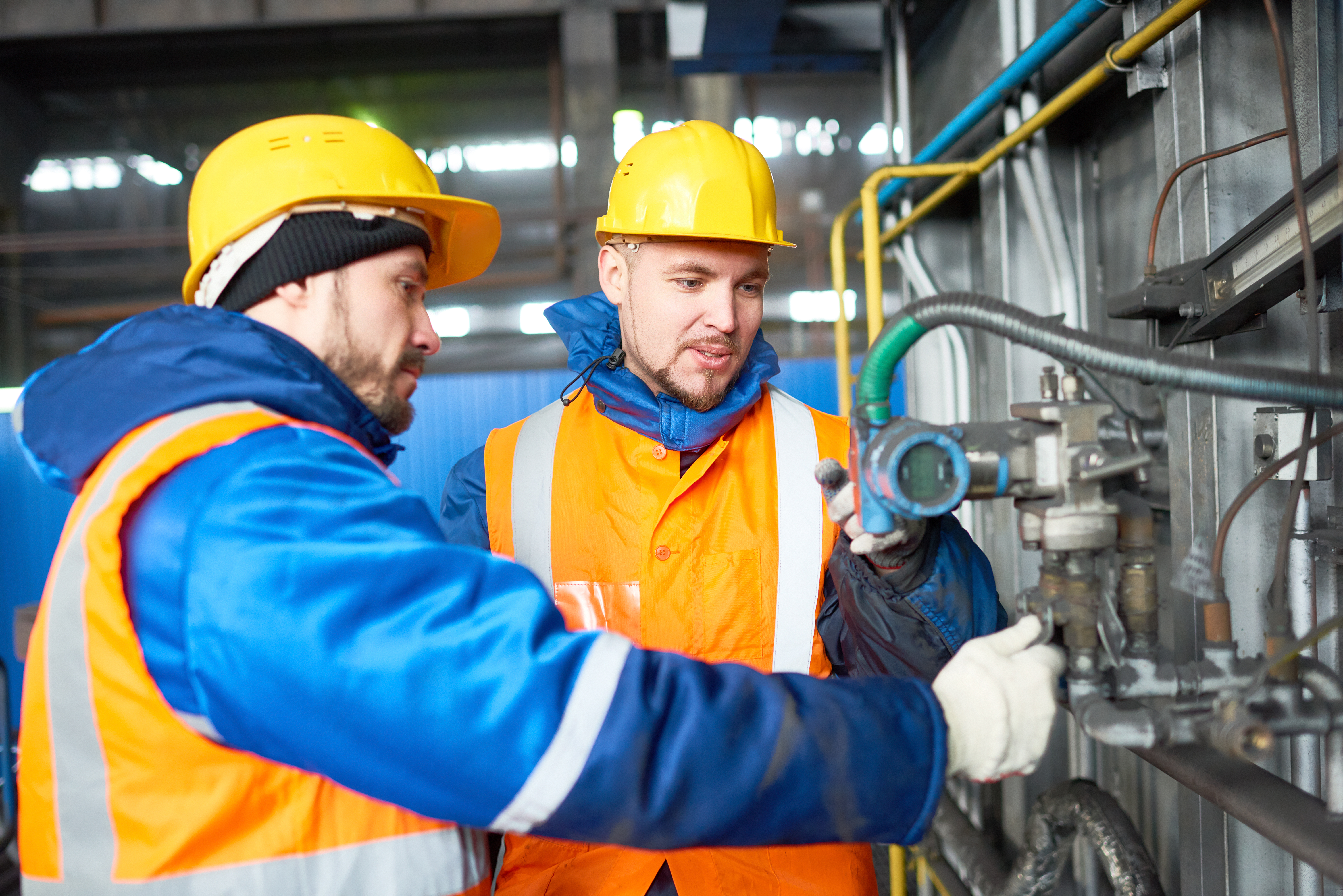 Two Men Inspecting Manufacturing Equipment in a Factory