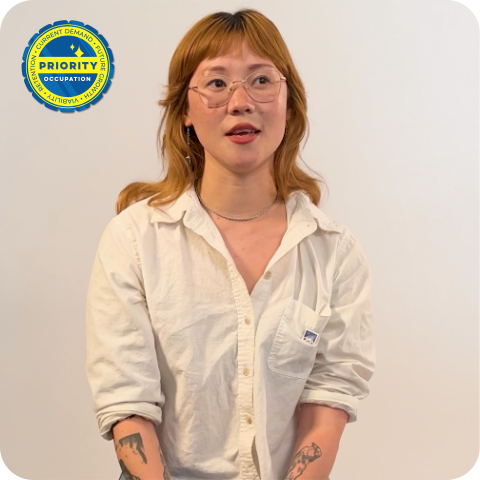 Woman in white button up shirt in front of white wall 