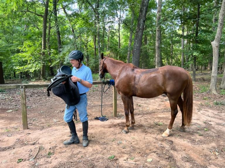 Outdoor photo of Calvert Training Stables staff member with horse 