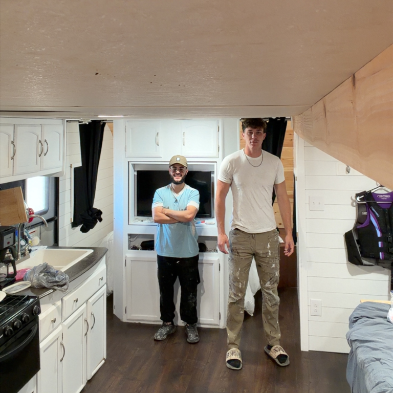 Two men stand in a small kitchen